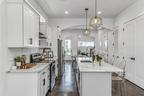 a kitchen with kitchen island granite countertop a sink a counter space and stainless steel appliances