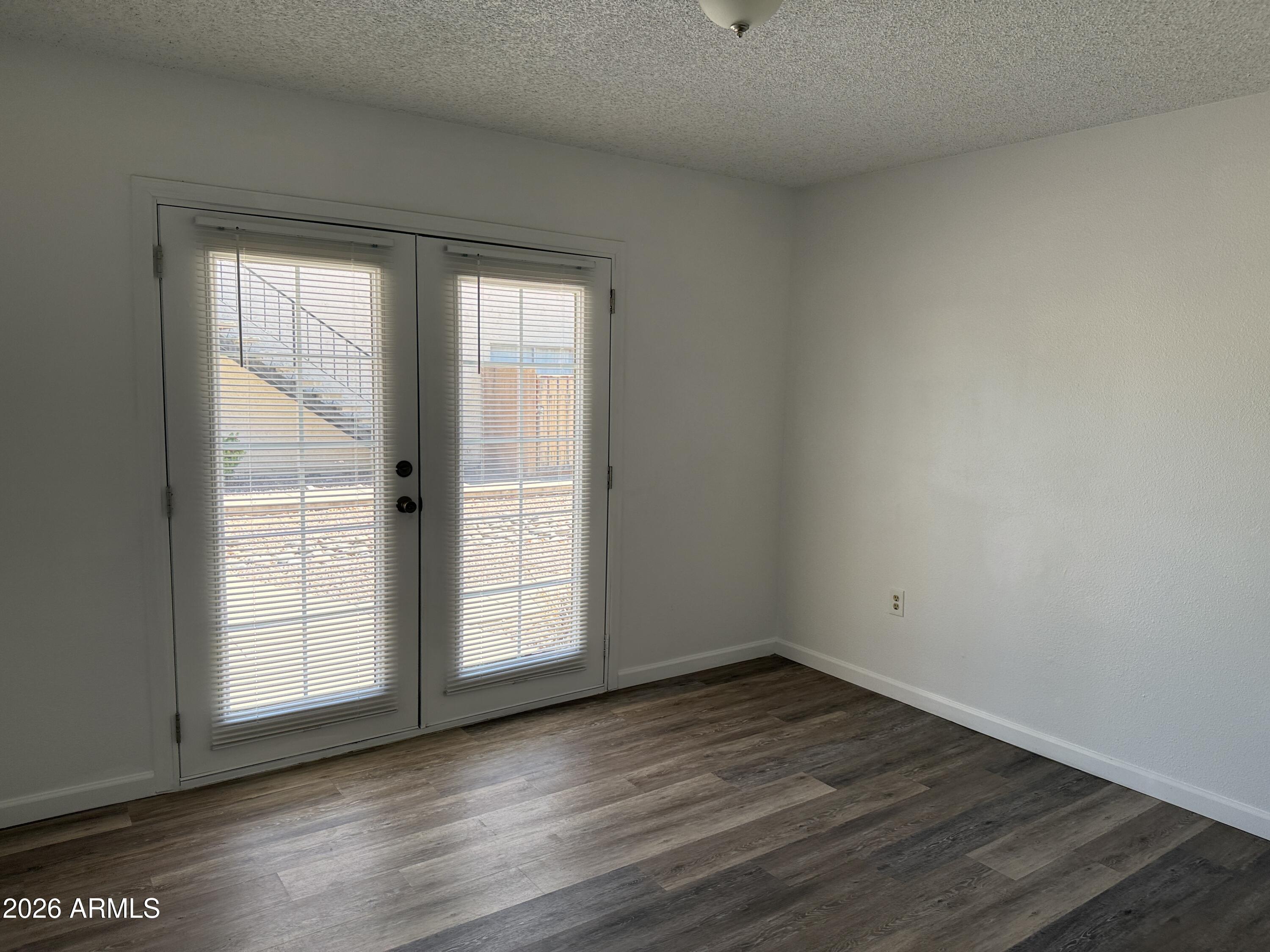 860 East Brown Road, Unit 53 Mesa, AZ 85203 - Photo 9 of 14 an empty room with wooden floor and windows