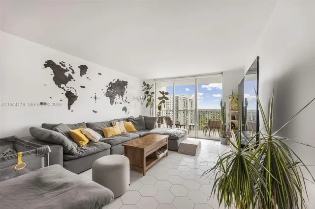 a living room with furniture and a floor to ceiling window