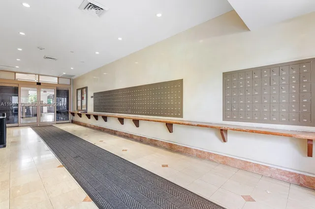 a large white kitchen with stainless steel appliances a large counter top