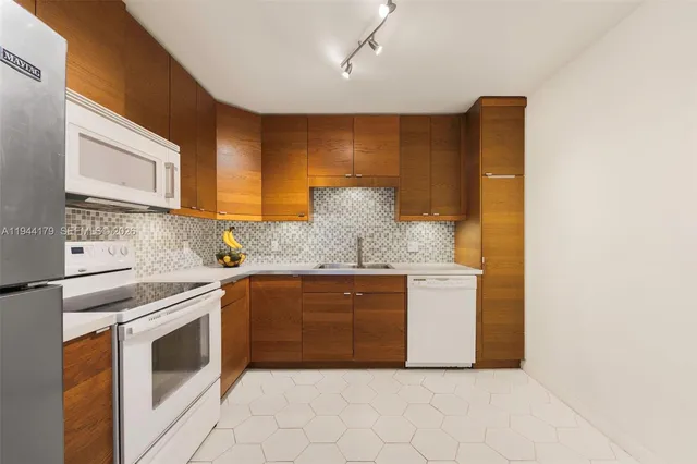 a kitchen with granite countertop white cabinets and white appliances