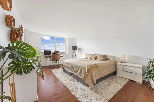 a spacious bedroom with a bed and a potted plant