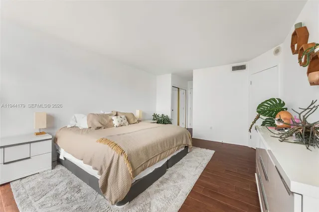 a bedroom with a bed and a potted plant