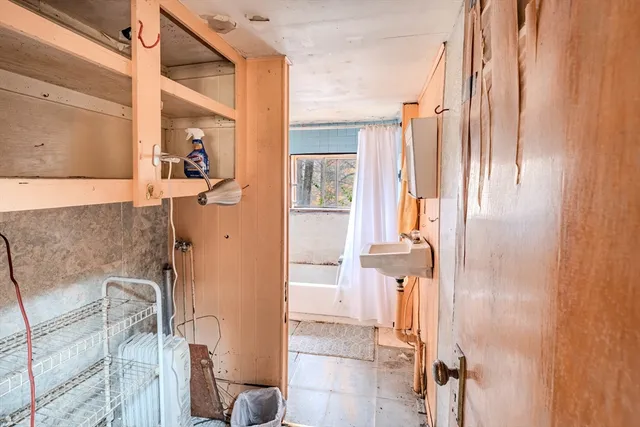 a bathroom with a tub a sink and a window