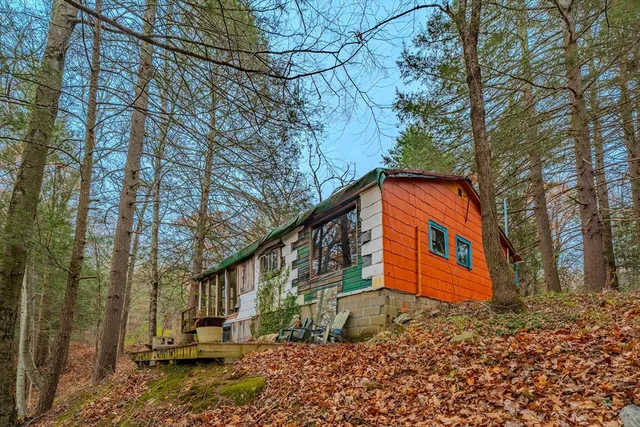 a wooden house with trees in the background