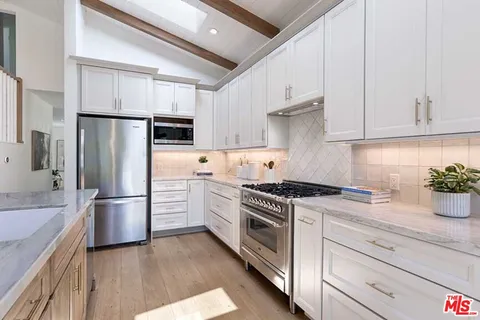 a kitchen with white cabinets and stainless steel appliances