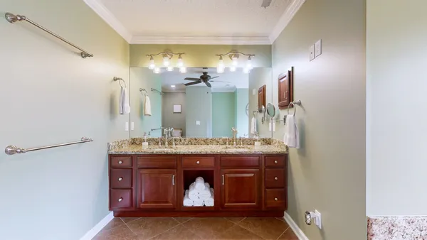 a bathroom with a granite countertop sink a mirror and a shower