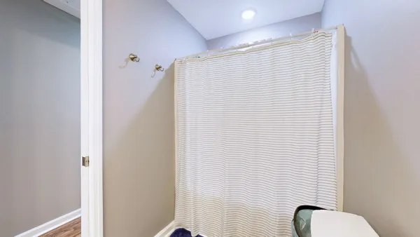 a bathroom with a toilet and a shower curtain