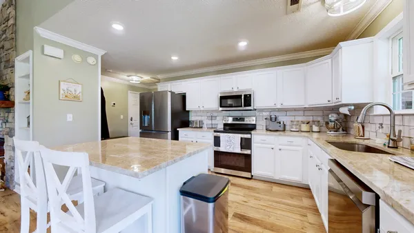 a kitchen with sink a microwave and cabinets