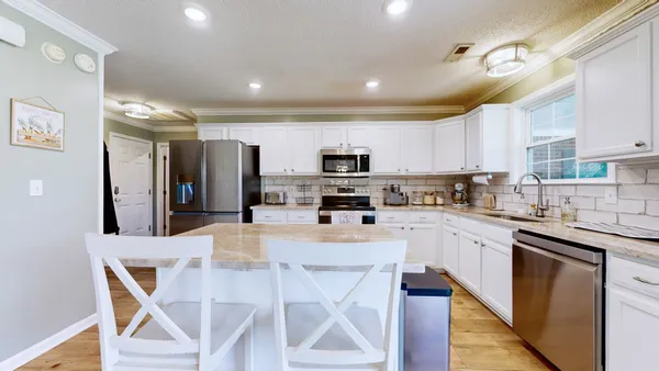 a kitchen with stainless steel appliances kitchen island granite countertop a sink and cabinets