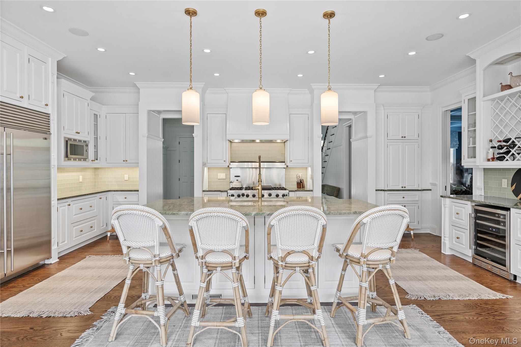 327 Georgica Road East Hampton, NY 11937 - Photo 8 of 36 a large kitchen with stainless steel appliances kitchen island granite countertop a dining table chairs and a white cabinets
