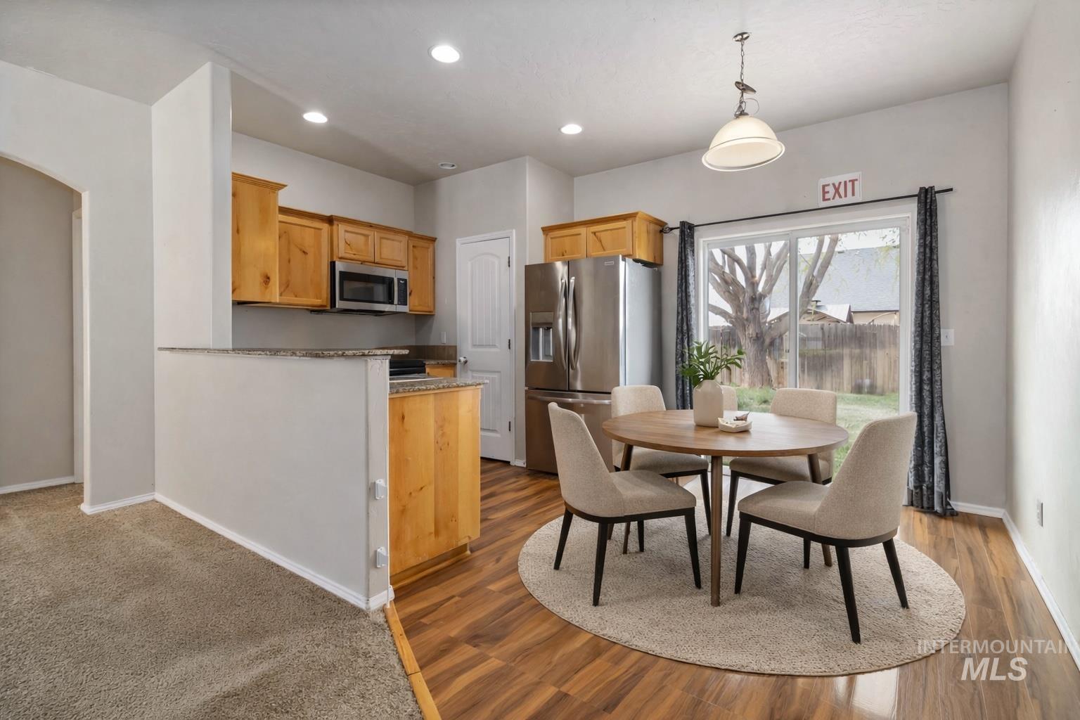 16053 Sunnyfield Avenue Caldwell, ID 83607 - Photo 10 of 35 Kitchen featuring stainless steel appliances, a peninsula, decorative light fixtures, and light wood-style floors