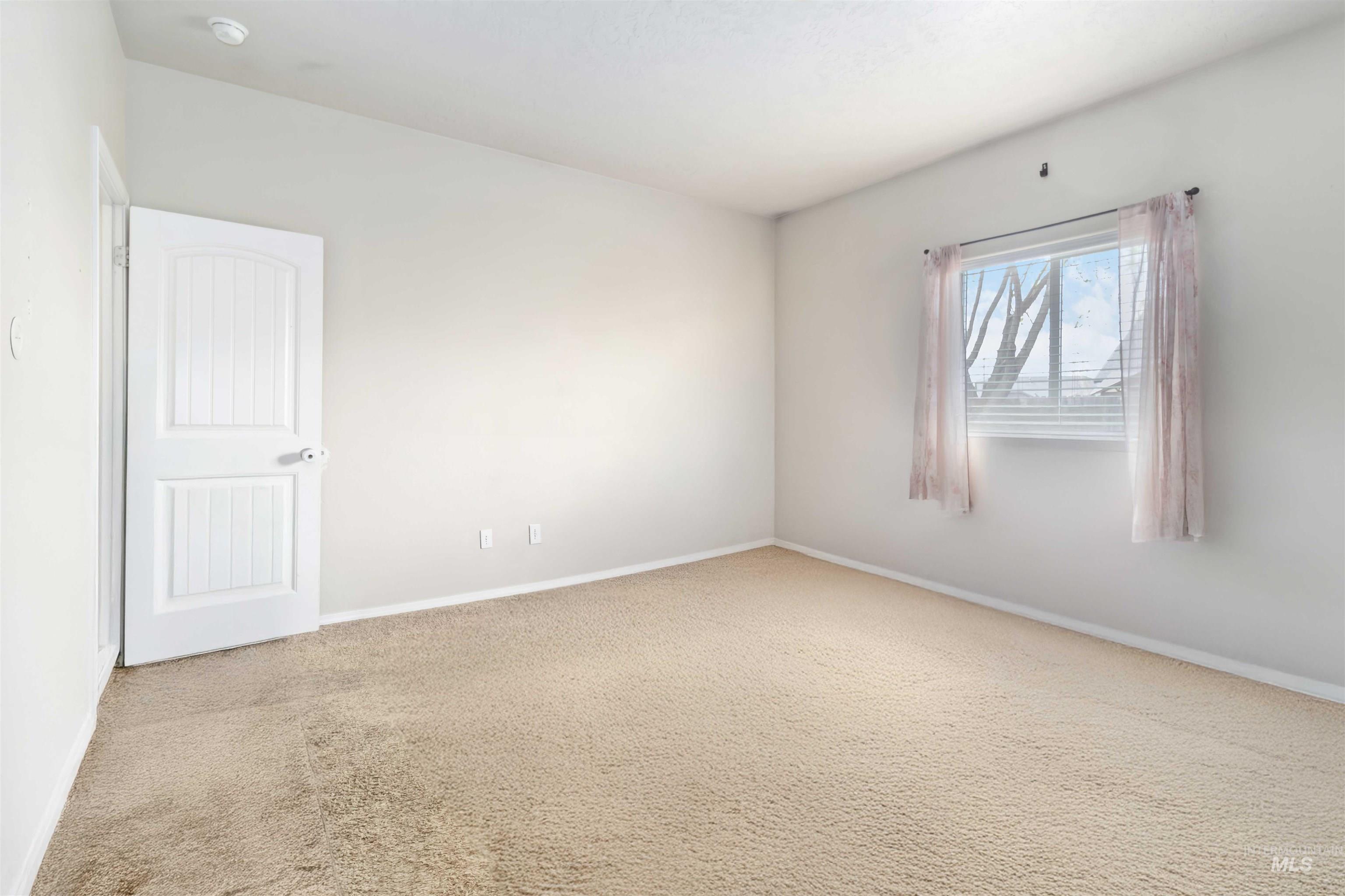 16053 Sunnyfield Avenue Caldwell, ID 83607 - Photo 18 of 35 Empty room featuring light carpet and baseboards