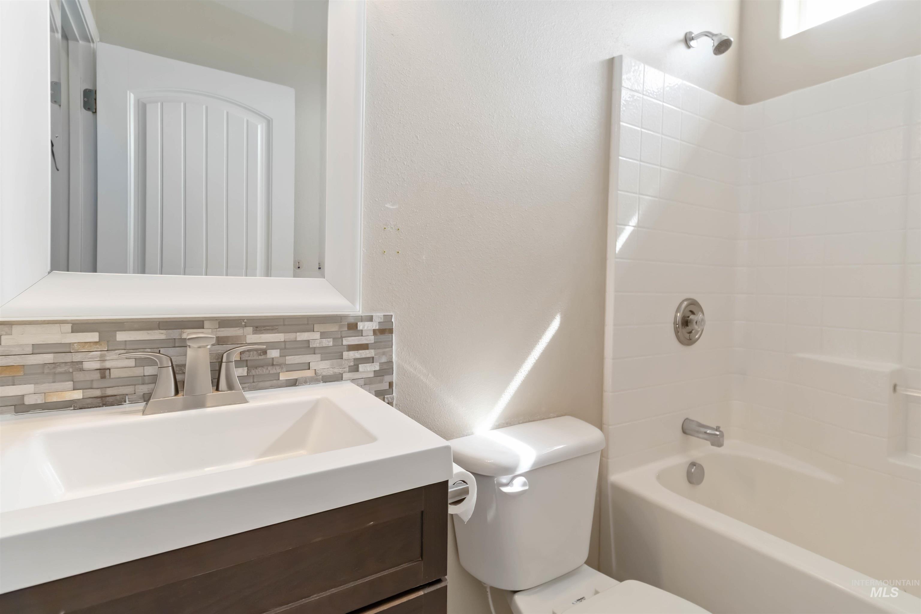 16053 Sunnyfield Avenue Caldwell, ID 83607 - Photo 25 of 35 Full bathroom with vanity, shower / washtub combination, decorative backsplash, and a textured wall