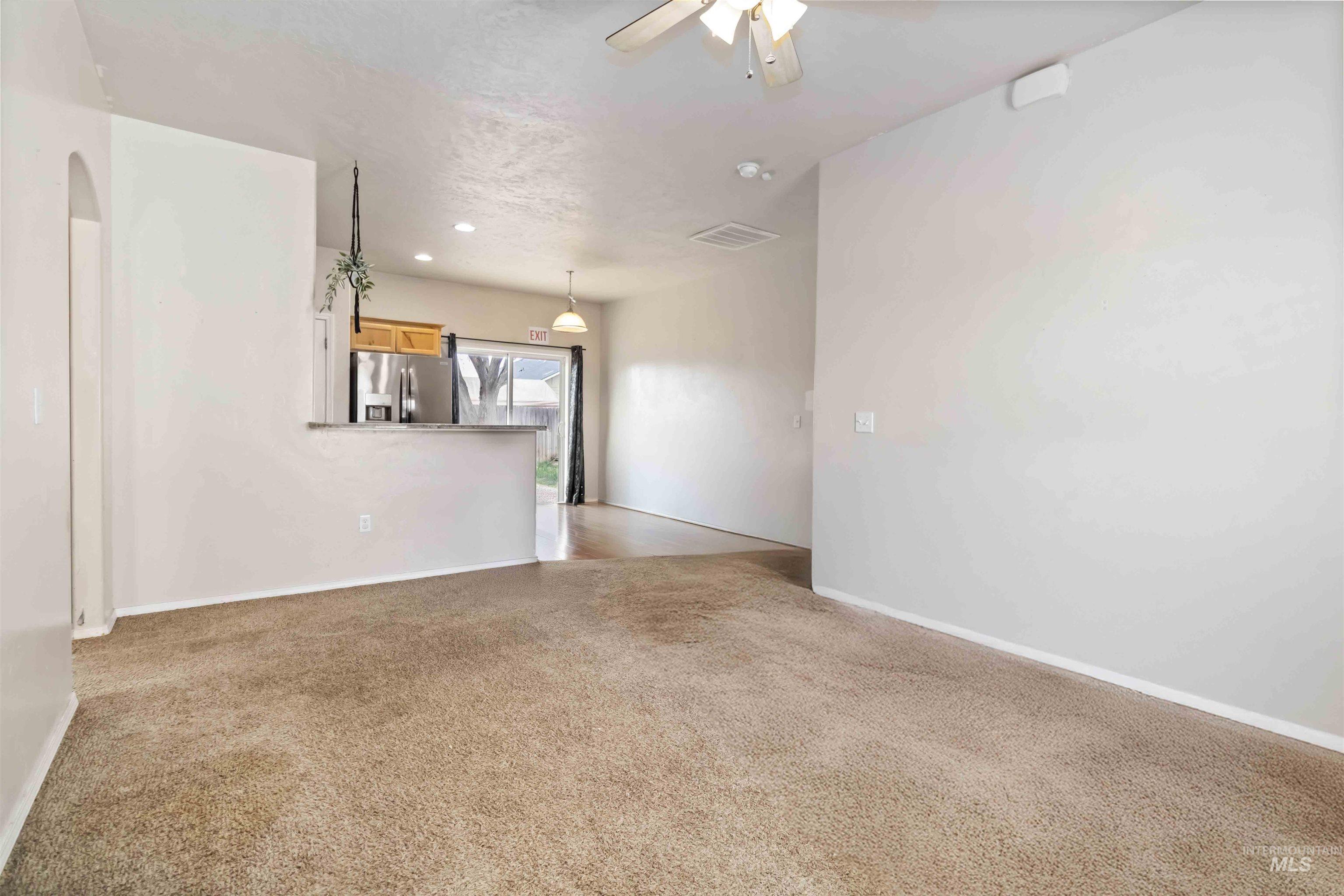 16053 Sunnyfield Avenue Caldwell, ID 83607 - Photo 6 of 35 Empty room with ceiling fan, light colored carpet, and recessed lighting