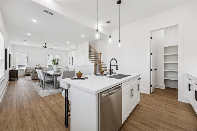 a large kitchen with stainless steel appliances a lot of counter space and a wooden floor