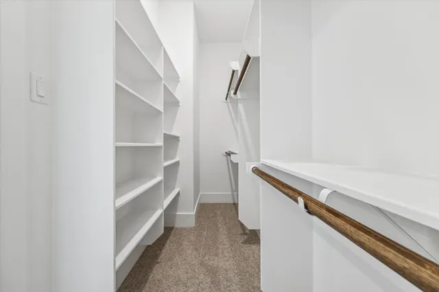 a view of walk in closet with empty racks