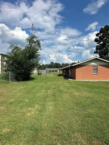 a view of a big yard with swimming pool and green space
