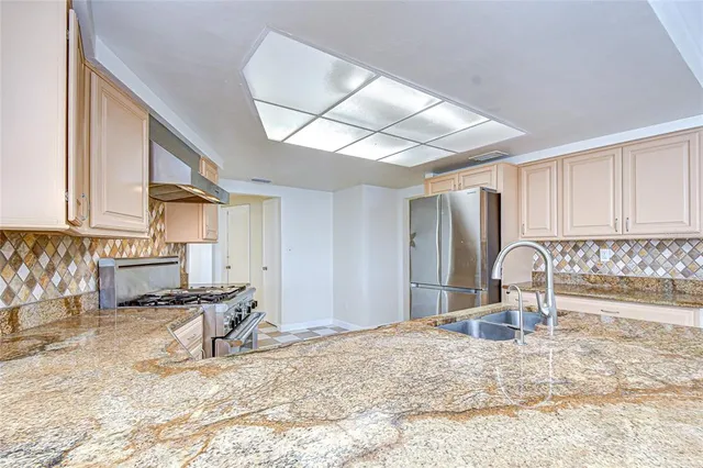 a kitchen with granite countertop a sink and a stove top oven
