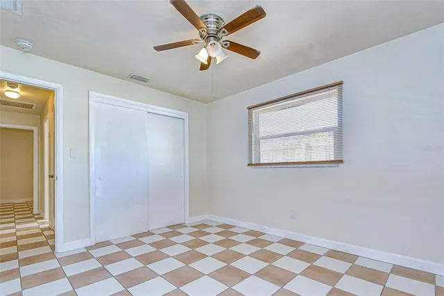 a view of a big room with wooden floor and a chandelier fan