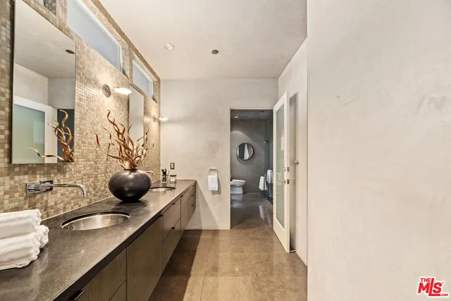 a bathroom with a granite countertop sink a toilet and shower