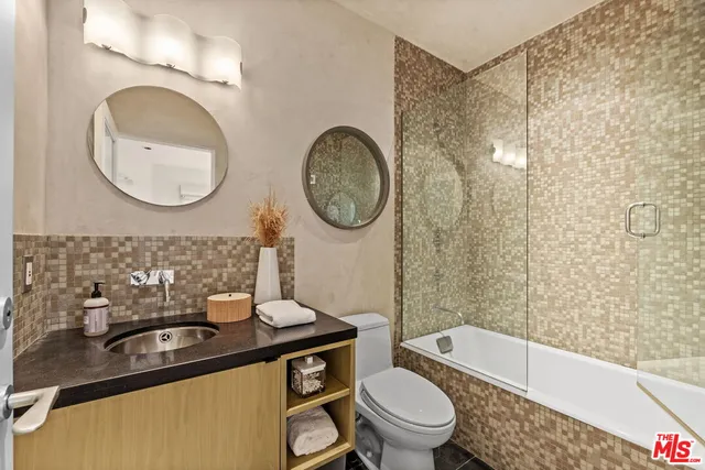 a bathroom with a sink a toilet and a mirror