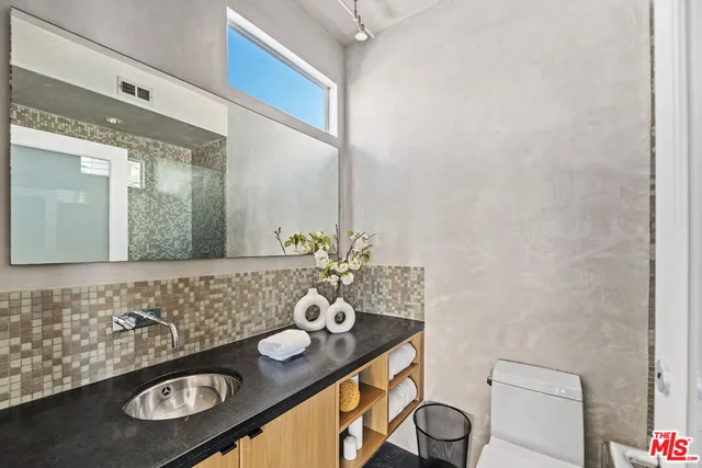 a bathroom with a granite countertop double vanity and a mirror