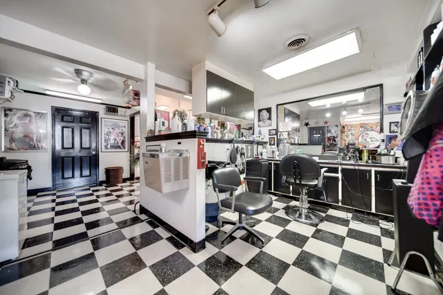 a living room with a black white checkered floor with couches chair and a coffee table