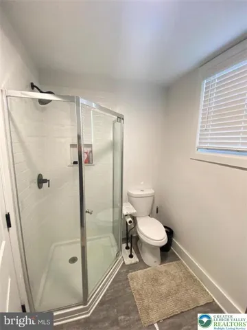 a bathroom with a toilet and a shower
