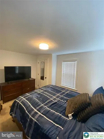 a bedroom with a bed and a television