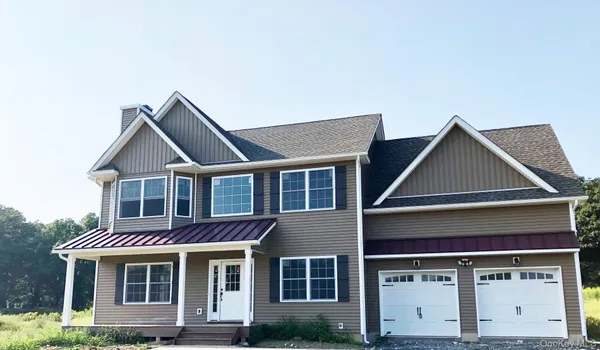 a front view of a house with yard and parking