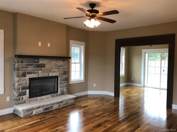 a living room with a fireplace and wooden floor