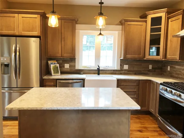 a kitchen with stainless steel appliances granite countertop a sink a stove and a refrigerator
