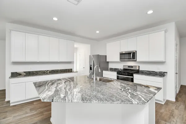 a kitchen with stainless steel appliances granite countertop a sink stove and microwave