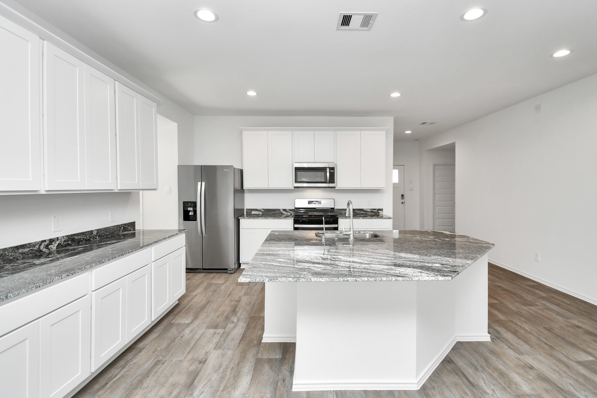 2715 Willow Gulch Way Rosenberg, TX 77469 - Photo 12 of 39 a large kitchen with stainless steel appliances granite countertop a stove a sink a refrigerator and white cabinets with wooden floor