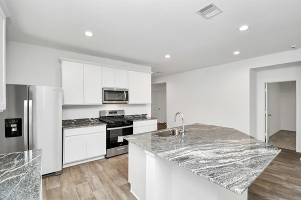 a large kitchen with stainless steel appliances granite countertop a stove and a sink