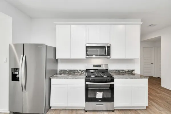 a kitchen with white cabinets and stainless steel appliances