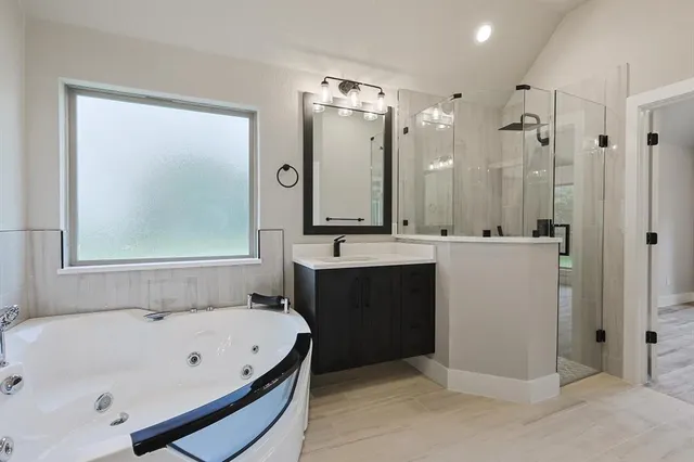 a bathroom with a bathtub a sink a mirror and a shower