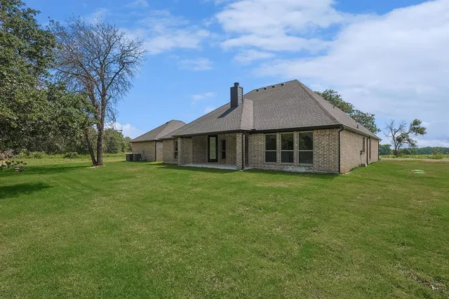 a house with huge green field in front of it