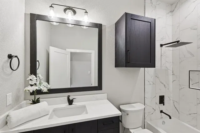 a bathroom with a sink toilet double vanity and shower