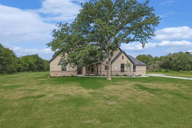 a house with huge green field in front of it