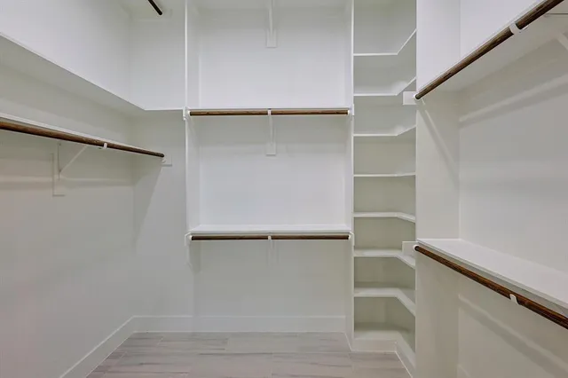 a view of walk in closet with empty racks