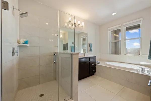 a bathroom with a tub shower and sink
