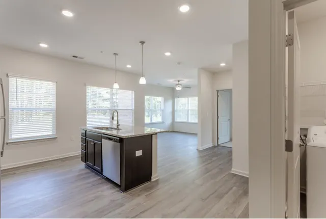 a large kitchen with stainless steel appliances granite countertop a large counter top and a wooden floors