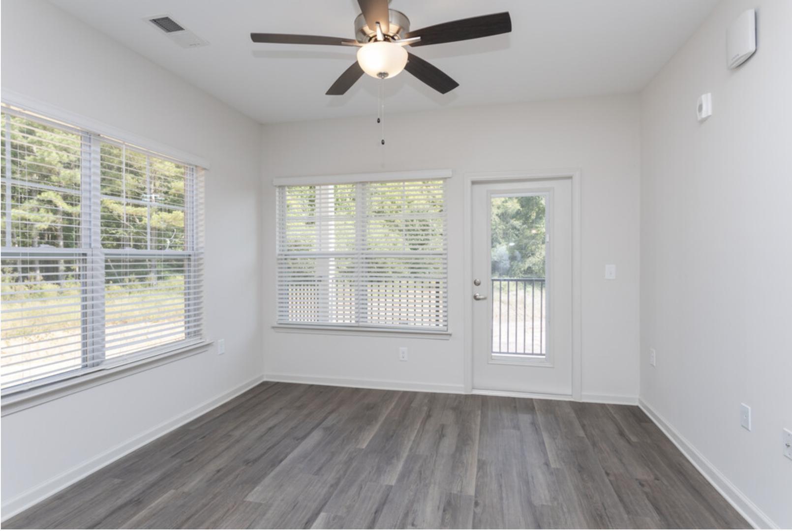 210 Grove Circle, Unit 103 Lillington, NC 27546 - Photo 6 of 13 a view of an empty room with wooden floor and a window