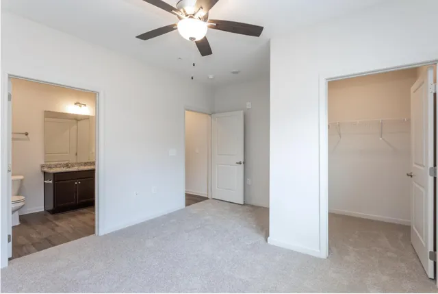 an empty room with a ceiling fan and a bathroom