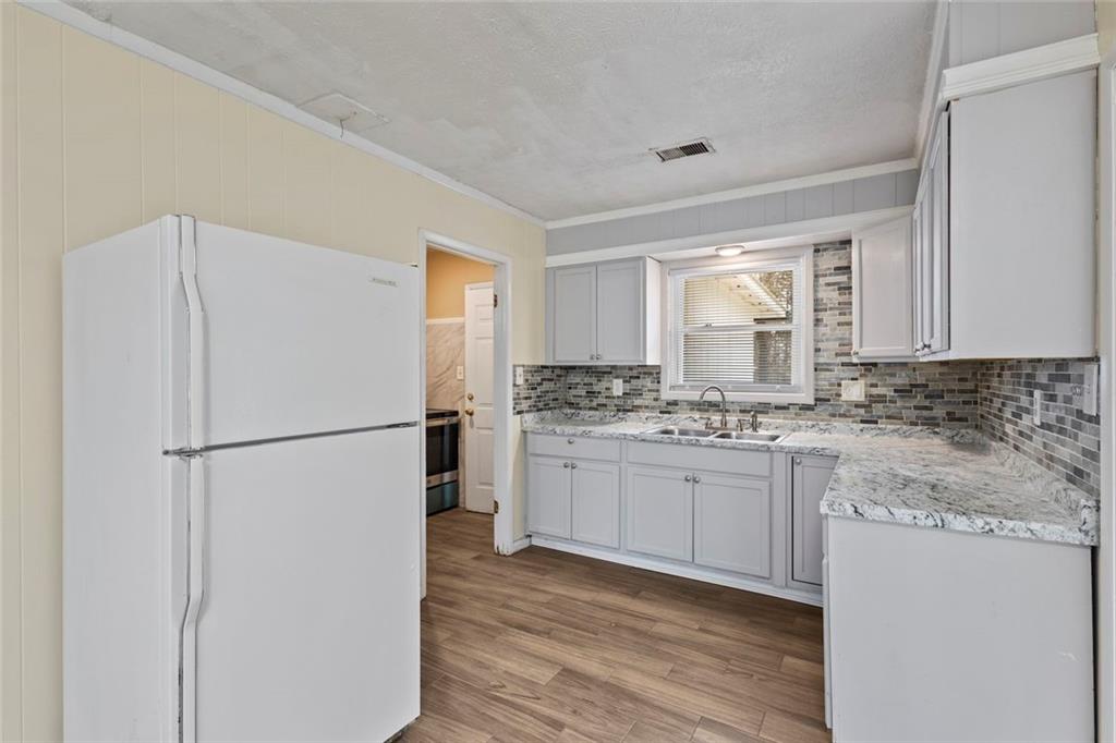 1201 Shoreham Drive Atlanta, GA 30349 - Photo 3 of 21 a kitchen with a refrigerator sink stove and cabinets