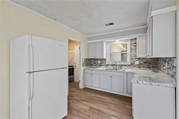 a kitchen with a refrigerator sink stove and cabinets