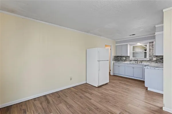 a kitchen with a refrigerator and white cabinets