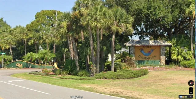 a view of a yard in front of a brick house with large tree